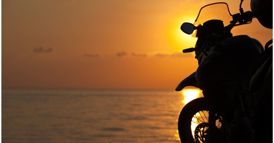 Motorcycle in the foreground as the sun is rising.