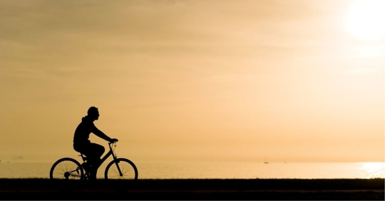 Bicyclist riding along the ocean shore