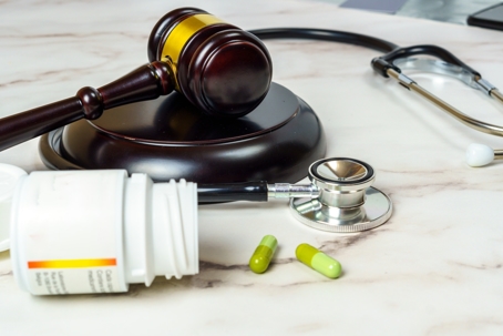 Gavel next to open medical bottle