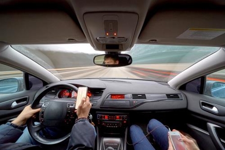 A driver looking on their phone while driving